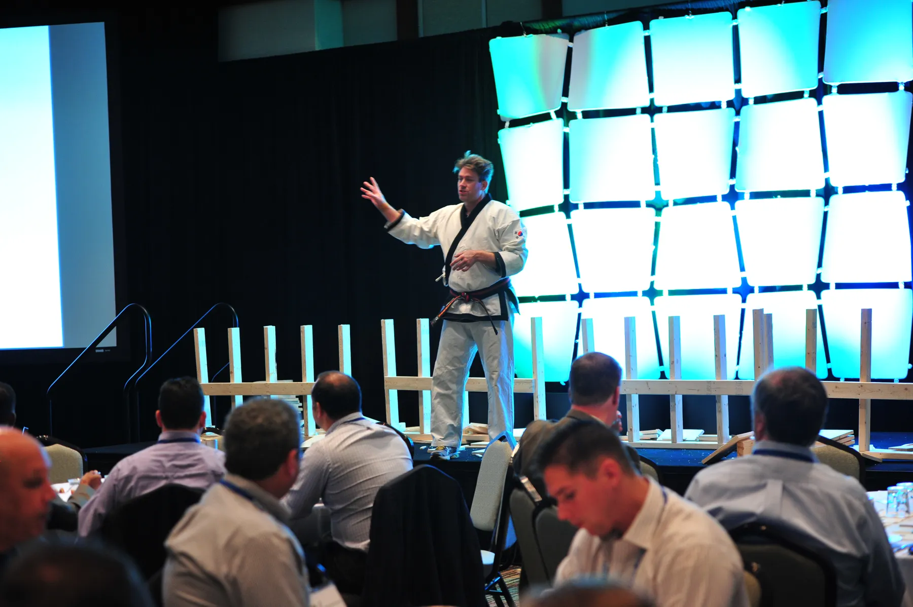 Leif Becker on stage at a corporate event, with boards set up for the audience board-break